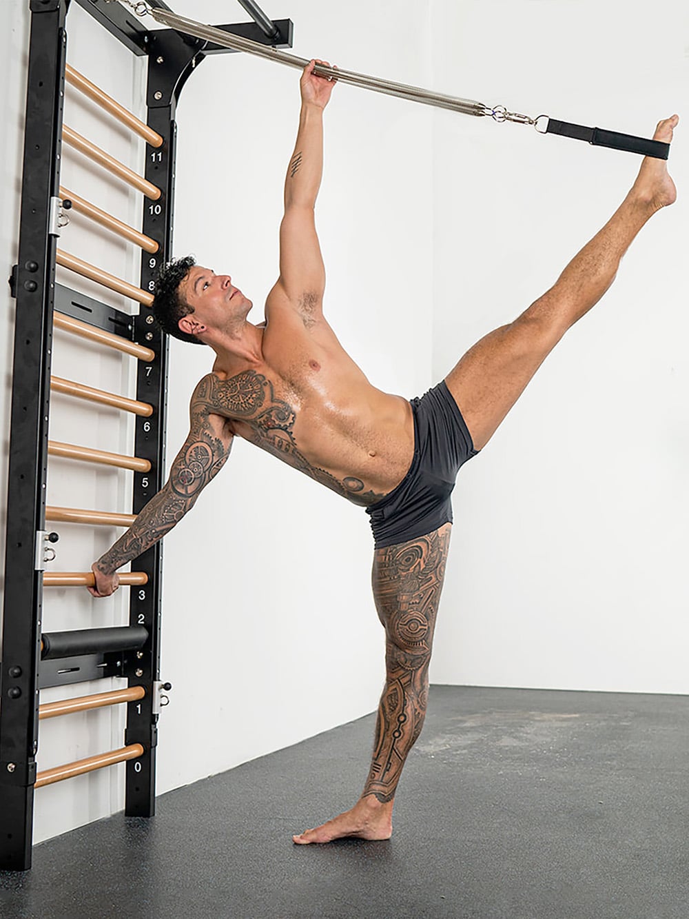 Fitness guru uses the Fuse Ladder Pilates apparatus to stretch and strengthen core.