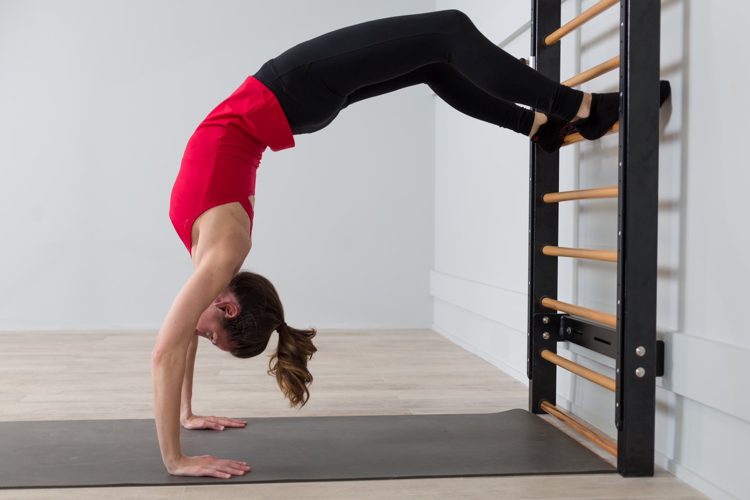 Pilates Anytime and Neuro Studio instructor Mariska Breland uses Fuse Ladder stall bars for yoga backbend.
