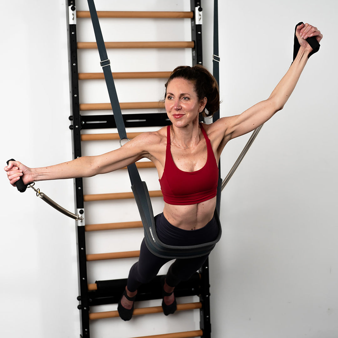 BASI Pilates and Power Pilates trained instructor Mariska Breland uses the yoga wall yoga sling for a calisthenics exercise on Fuse Ladder.